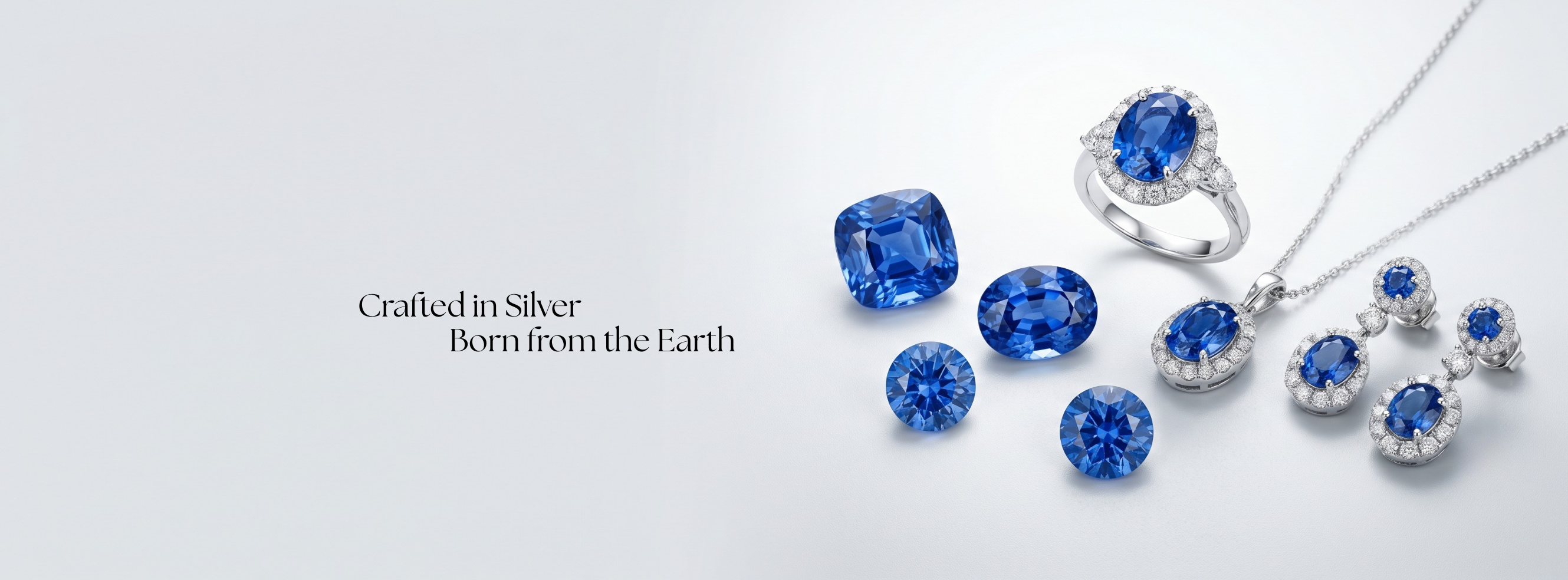 Ceylon blue sapphires beside a silver halo ring, pendant and earrings. Crafted in silver, born from the earth.